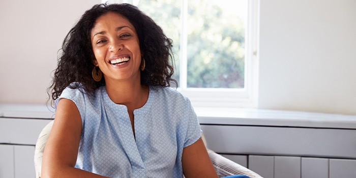 Woman smiling while sitting on chair at home