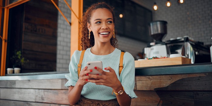 Smiling woman sitting on barstool at restaurant