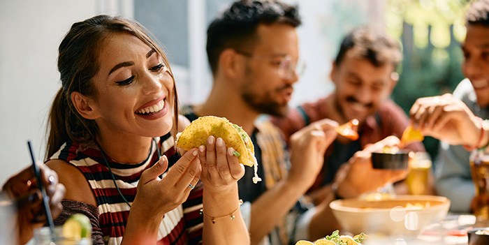 Woman smiling while eating lunch with friends at restaurant