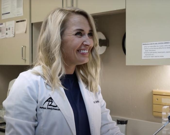 Doctor Williams grinning while talking to a dental patient